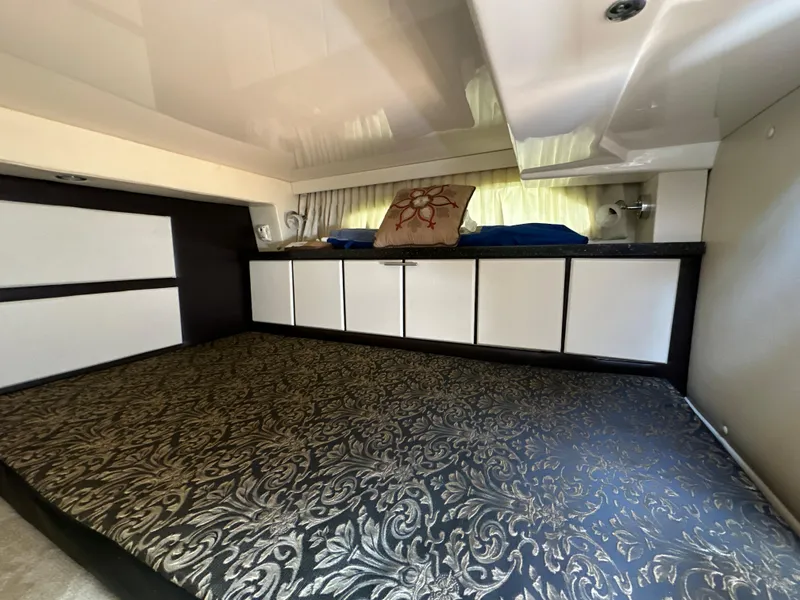Slide: The Image of Interior cabin of 2015 Regal 32 Express with patterned bedding and storage cabinets. - 21