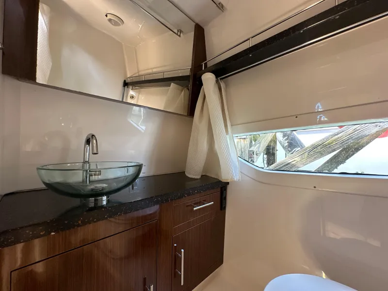 Slide: The Image of 2015 Regal 32 Express bathroom with glass sink and wooden cabinetry. - 22