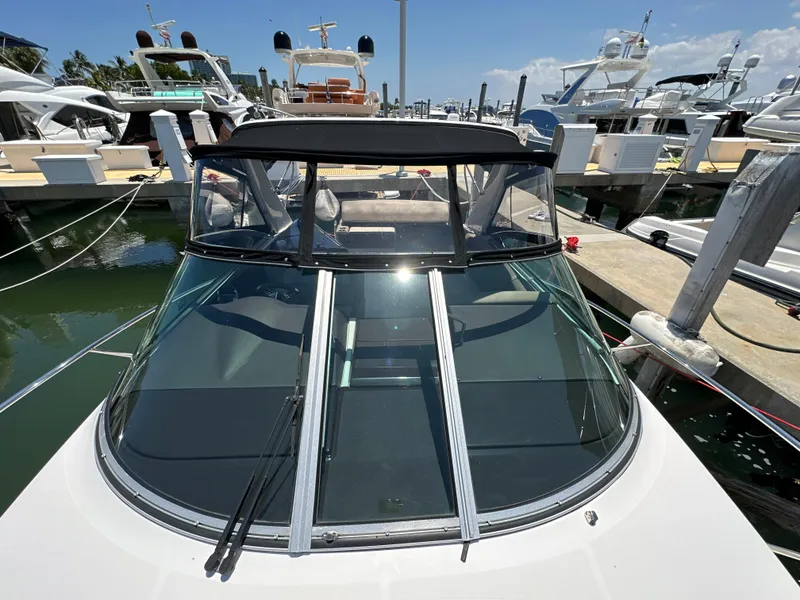 Slide: The Image of 2015 Regal 32 Express boat docked at marina, front view with clear windshield. - 25