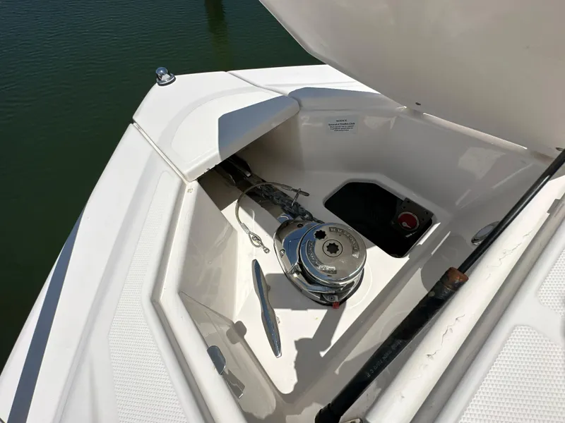 Slide: The Image of 2015 Regal 32 Express boat anchor compartment with winch, open hatch, and water view. - 26