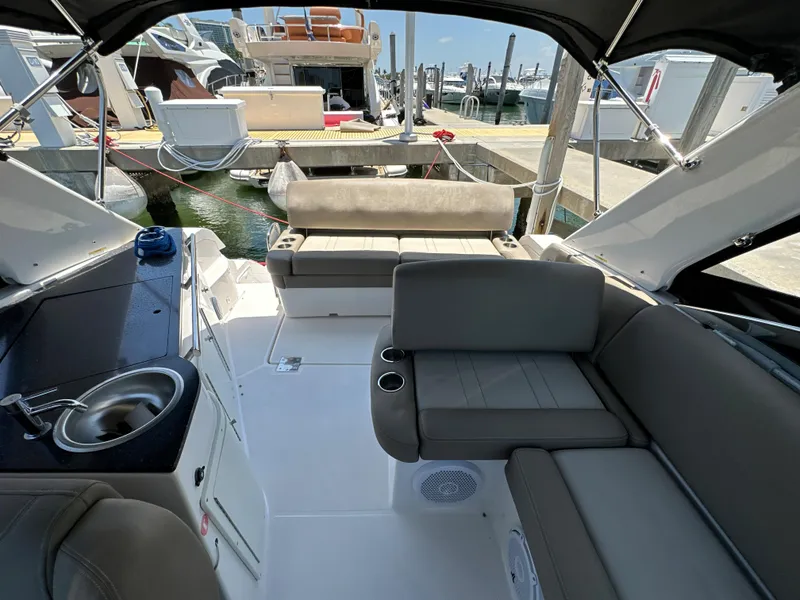 Slide: The Image of 2015 Regal 32 Express boat interior with seating and kitchenette at a marina. - 3