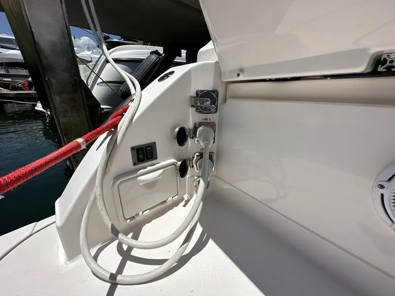 Slide: The Image of 2015 Regal 32 Express boat docked, showing power connections and red mooring line. - 32