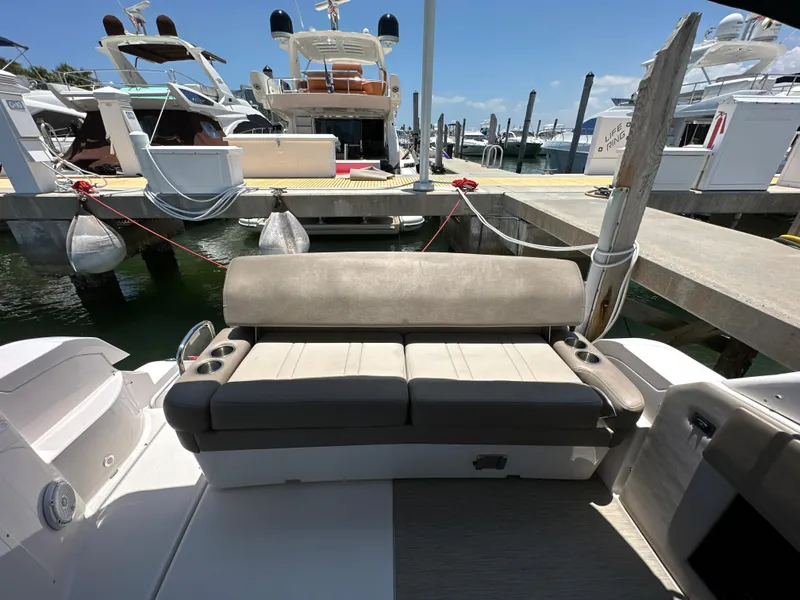 Slide: The Image of 2015 Regal 32 Express boat with cushioned seating at a marina dock. - 4