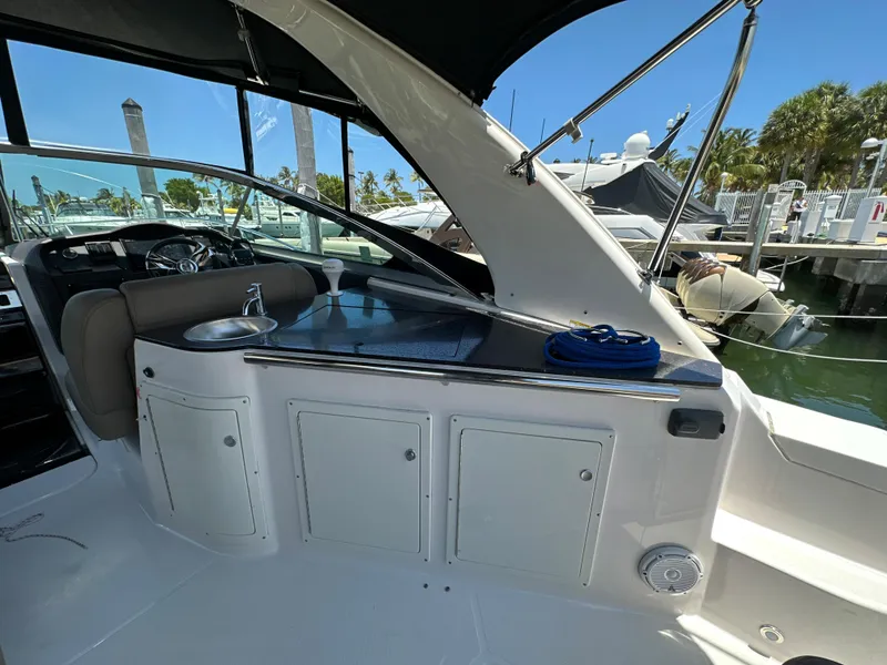 Slide: The Image of 2015 Regal 32 Express boat interior with kitchenette and seating area at marina. - 5