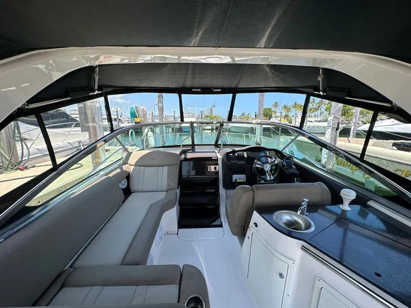 Slide: The Image of 2015 Regal 32 Express boat interior with seating, helm, and kitchenette. - 8