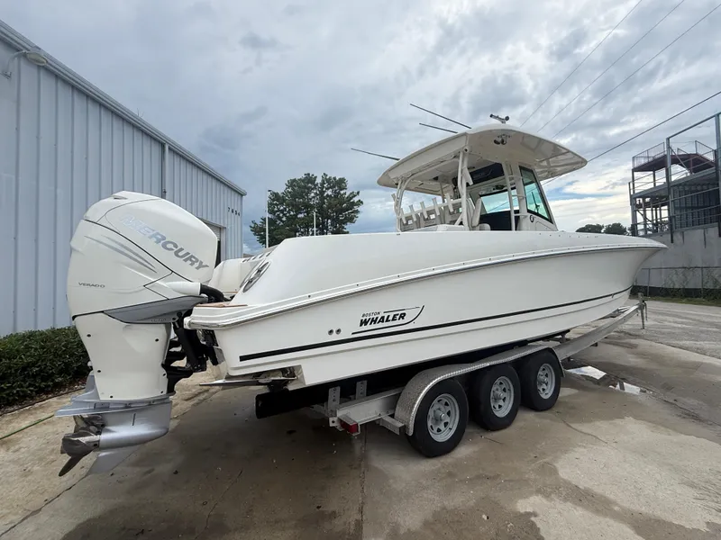 Slide: The Image of 2017 Boston Whaler 350 Outrage boat on trailer, parked outdoors. - 10