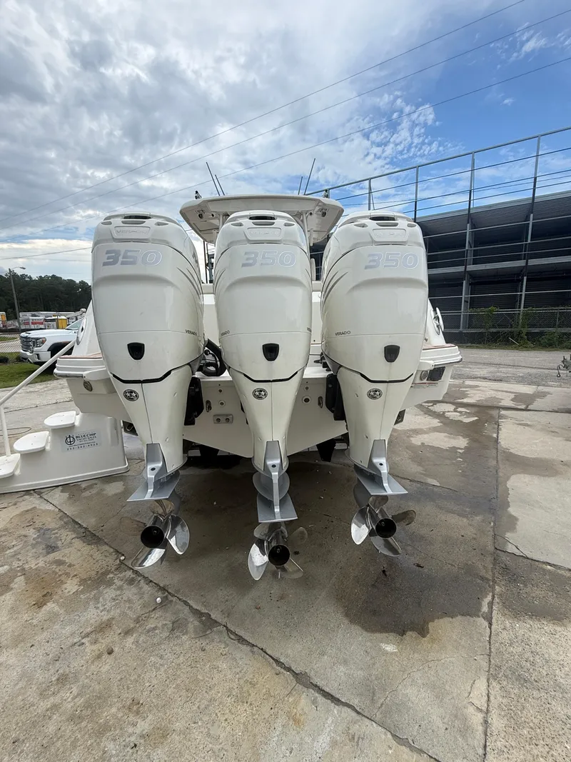 Slide: The Image of 2017 Boston Whaler 350 Outrage with triple outboard engines, docked outdoors. - 15