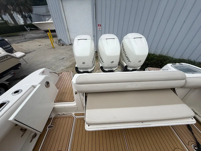 Slide: The Image of 2017 Boston Whaler 350 Outrage with triple Mercury outboard engines and cushioned seating. - 18