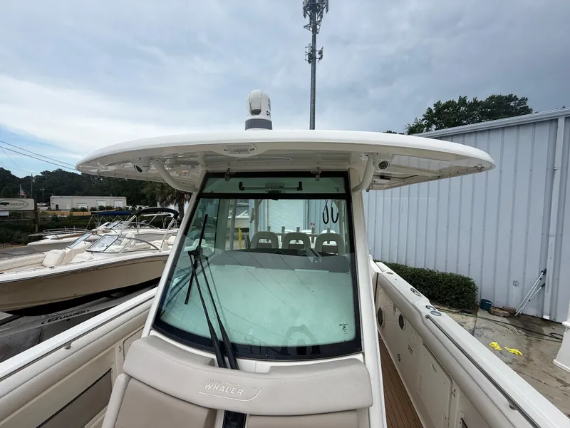 Slide: The Image of 2017 Boston Whaler 350 Outrage boat, front view, docked under cloudy sky. - 21