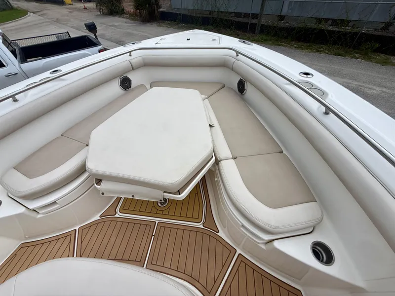 Slide: The Image of 2017 Boston Whaler 350 Outrage boat interior with cushioned seating and wooden flooring. - 24