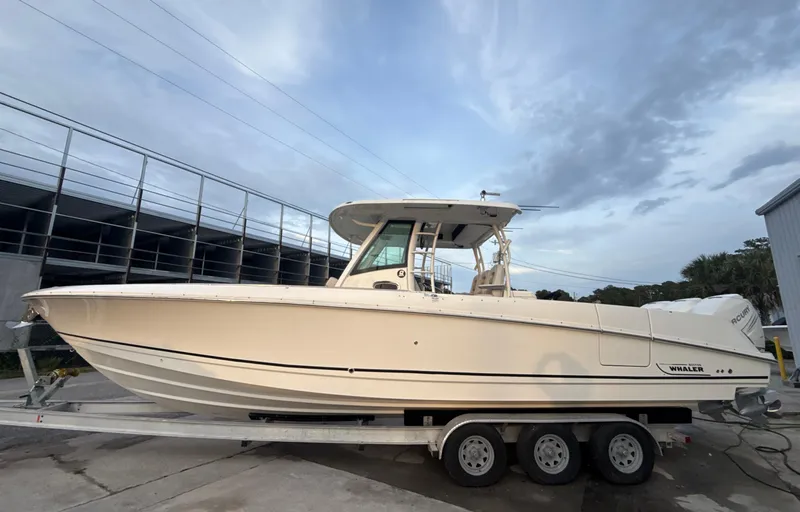 Slide: The Image of 2017 Boston Whaler 350 Outrage boat on a trailer, parked outdoors. - 3