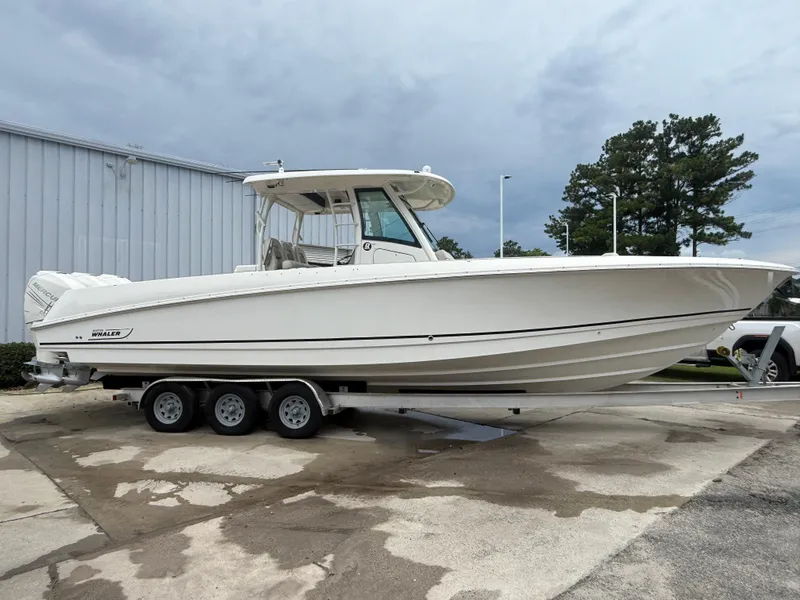 Slide: The Image of 2017 Boston Whaler 350 Outrage boat on a trailer, parked outdoors. - 6