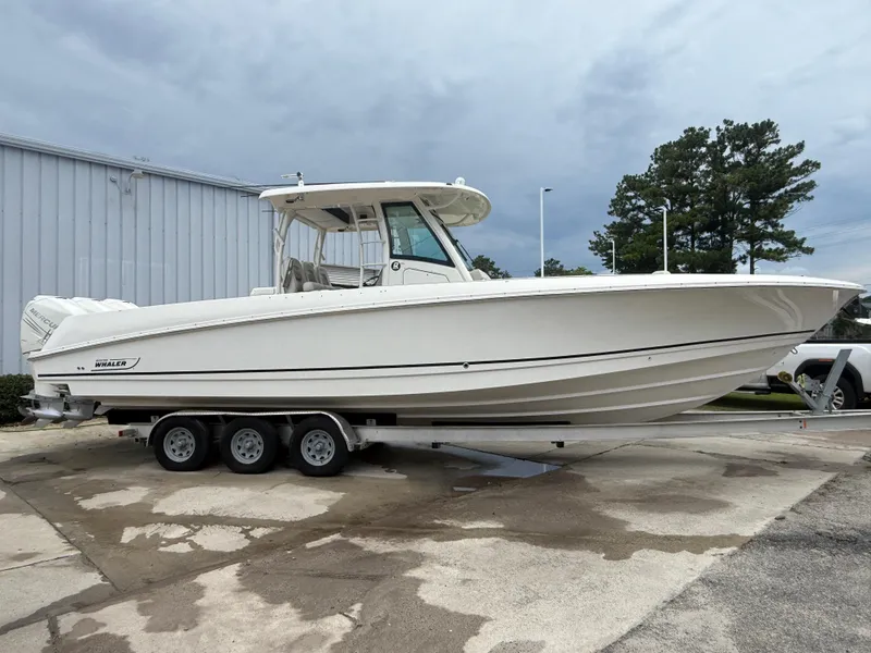 Slide: The Image of 2017 Boston Whaler 350 Outrage boat on trailer, parked outdoors. - 7