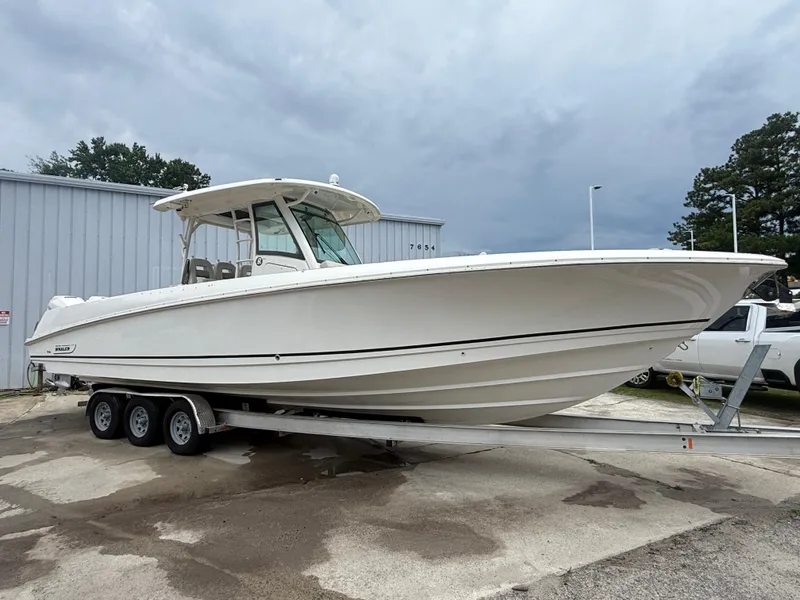 Slide: The Image of 2017 Boston Whaler 350 Outrage boat on trailer, parked outdoors. - 8