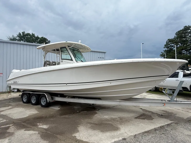 Slide: The Image of 2017 Boston Whaler 350 Outrage boat on trailer, parked outdoors. - 9
