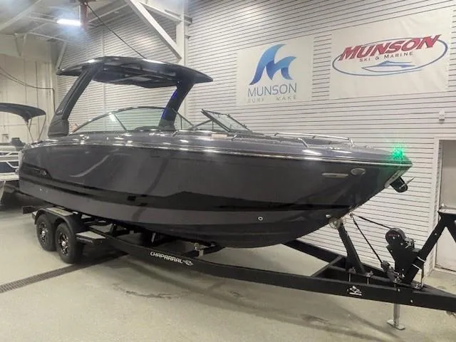 Slide: The Image of 2025 Chaparral 2870 boat on trailer in showroom, Munson sign in background. - 1