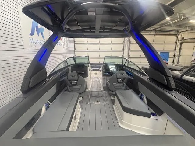 Slide: The Image of 2025 Chaparral 2870 boat interior with modern seating and sleek design in showroom. - 18