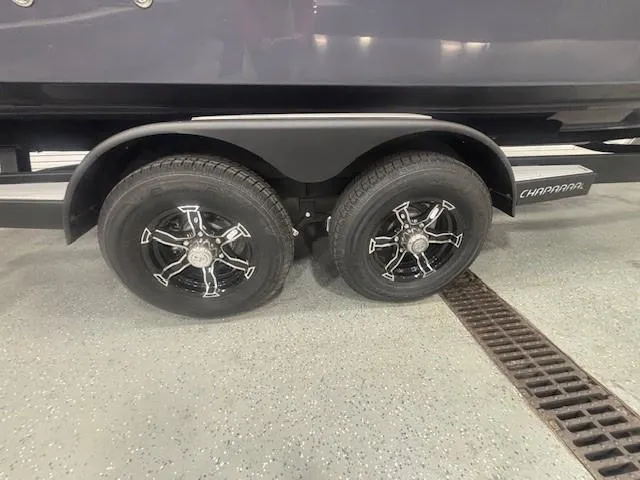 Slide: The Image of Trailer wheels of a 2025 Chaparral 2870 boat on a showroom floor. - 24