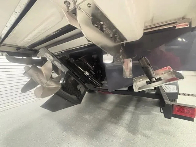 Slide: The Image of 2025 Chaparral 2870 boat stern with dual propellers and trim tabs in a garage. - 25