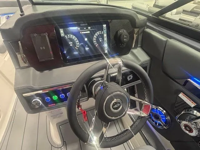 Slide: The Image of 2025 Chaparral 2870 boat dashboard with modern steering wheel and digital display. - 5