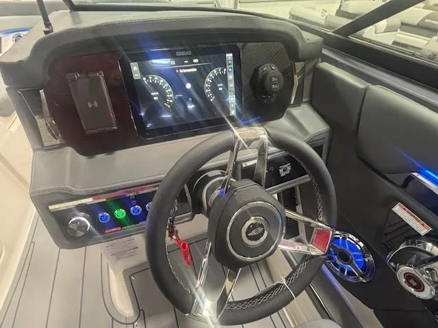 Slide: The Image of 2025 Chaparral 2870 boat dashboard with modern steering wheel and digital display. - 7