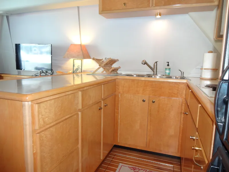Slide: The Image of 1998 Navigator 53 Classic yacht kitchen with wooden cabinetry and modern appliances. - 19