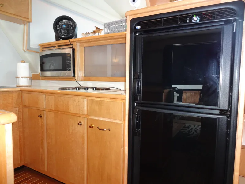Slide: The Image of Kitchen area of 1998 Navigator 53 Classic yacht with fridge, microwave, and wooden cabinets. - 20