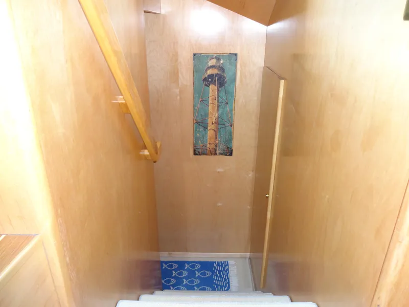 Slide: The Image of Staircase in 1998 Navigator 53 Classic yacht with wooden walls and lighthouse artwork. - 32