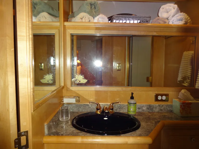 Slide: The Image of Bathroom vanity with mirror, black sink, and toiletries in a 1998 Navigator 53 Classic. - 48
