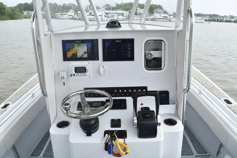 Slide: The Image of 2018 Contender 25T boat console with navigation screens and steering wheel. - 10