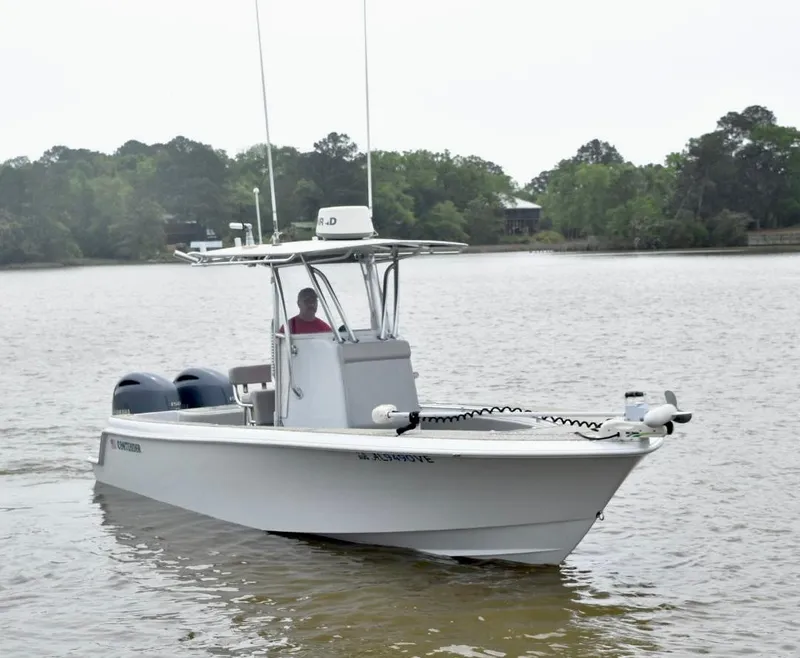 Slide: The Image of 2018 Contender 25T boat on calm water with trees in the background. - 2