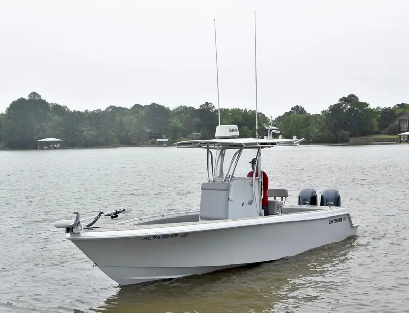 Slide: The Image of 2018 Contender 25T boat on a calm lake with wooded shoreline. - 5