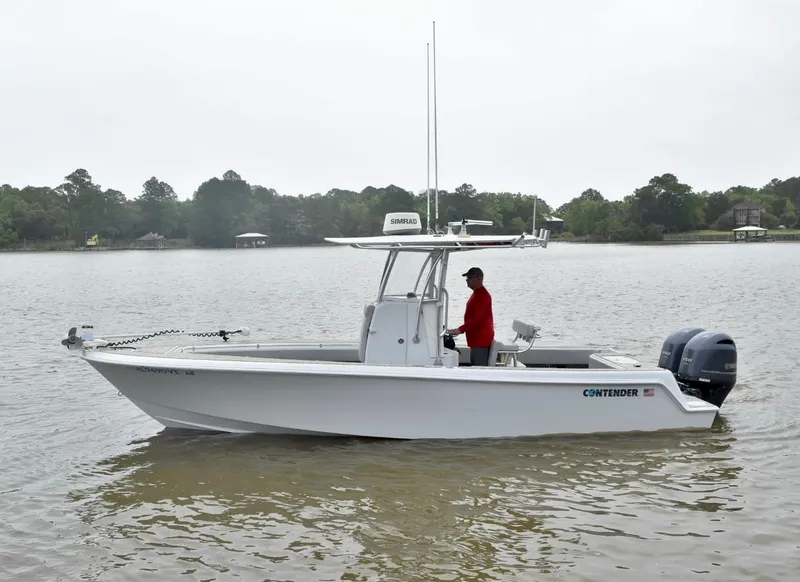 Slide: The Image of 2018 Contender 25T boat on calm water, with a person in a red shirt steering. - 6