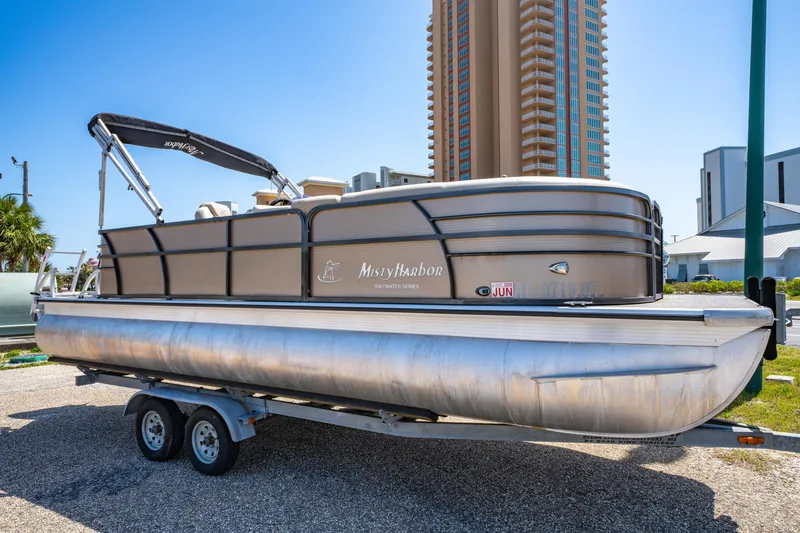 Slide: The Image of 2016 Misty Harbor 2285CS Biscayne Bay pontoon boat on trailer, urban background. - 1
