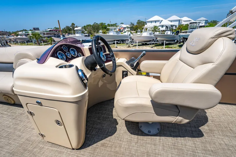Slide: The Image of 2016 Misty Harbor 2285CS Biscayne Bay boat interior with beige captain's chair and control panel. - 10