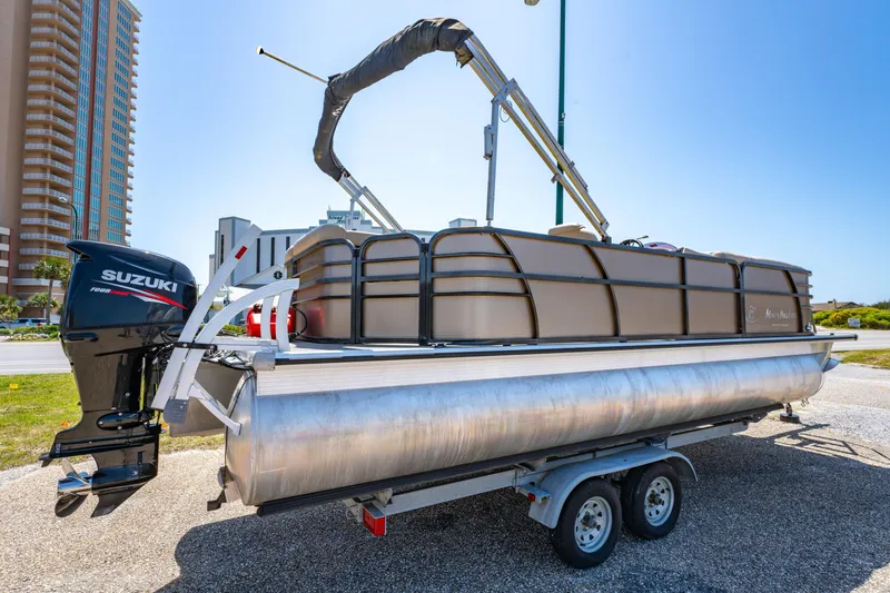 Slide: The Image of 2016 Misty Harbor 2285CS Biscayne Bay pontoon boat on trailer, featuring Suzuki outboard motor. - 2