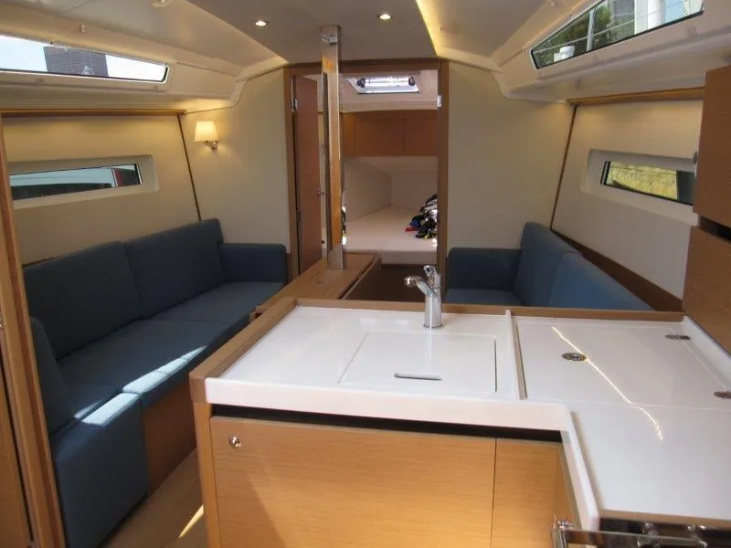 Slide: The Image of Interior of 2025 Jeanneau Sun Odyssey 350 yacht, featuring modern kitchen and seating area. - 38