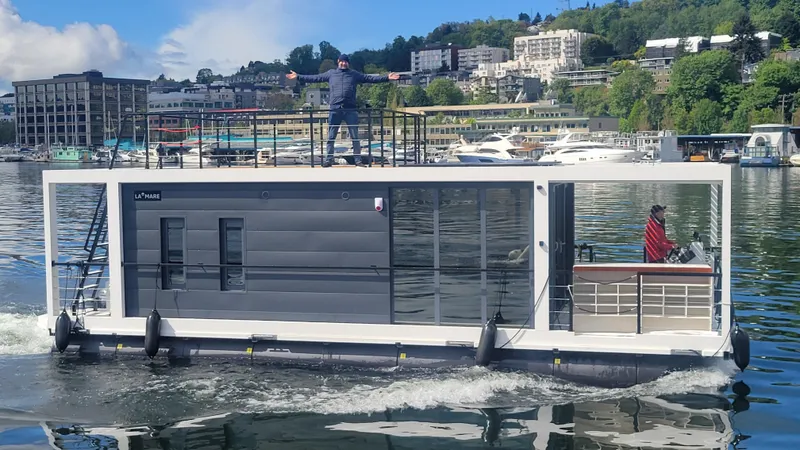 Slide: The Image of 2024 La Mare Modern 11 houseboat cruising on a scenic lake with urban backdrop. - 40