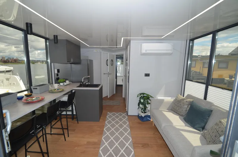 Slide: The Image of Modern 2024 La Mare houseboat interior with sleek kitchen, cozy living area, and large windows. - 7