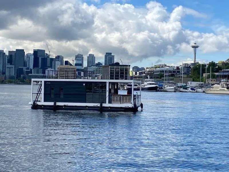 Slide: The Image of Floating houseboat "La Mare Modern 11" on urban waterfront, 2024 model, with city skyline backdrop. - 0