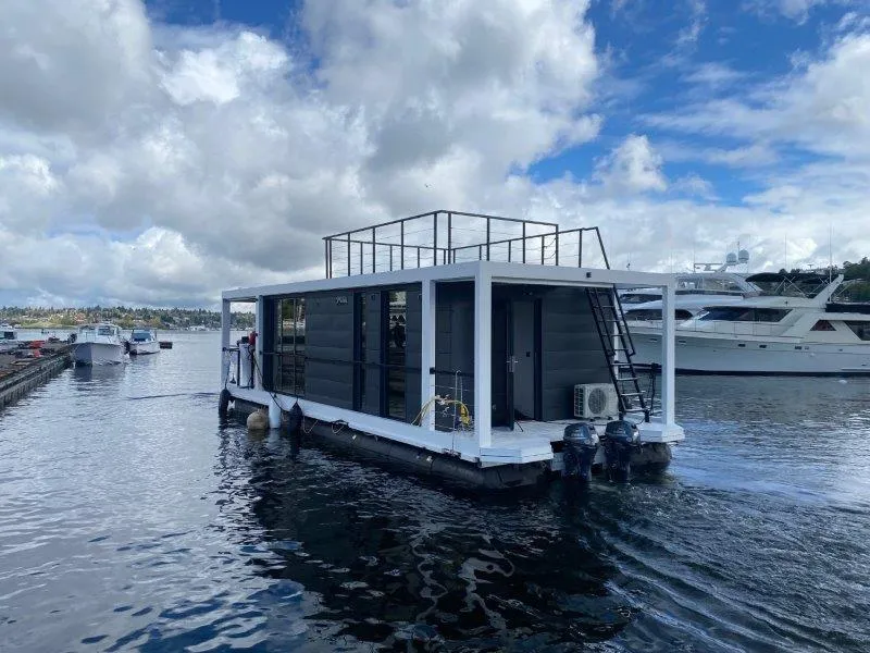 Slide: The Image of Modern 2024 La Mare houseboat on water, featuring sleek design and rooftop deck. - 1