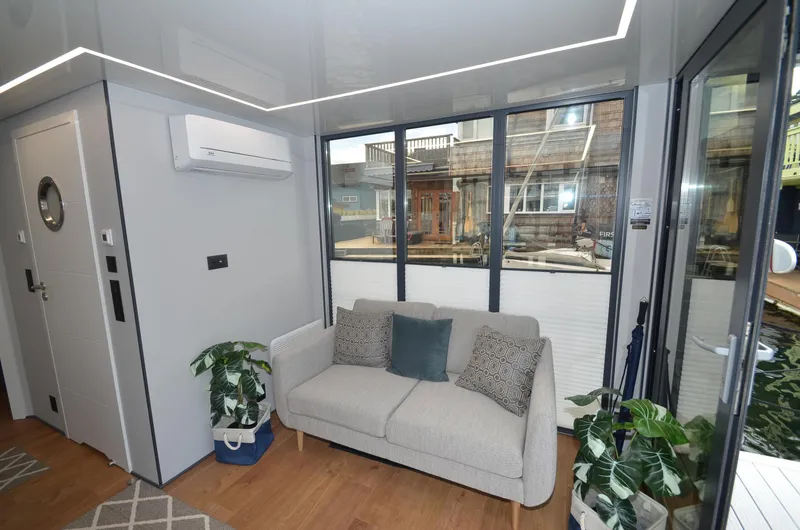 Slide: The Image of Modern living room in La Mare Modern 11 houseboat, 2024, with sofa and large windows. - 10