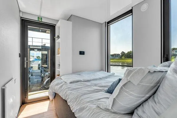 Slide: The Image of Modern bedroom in La Mare Modern 11 houseboat, 2024 model, with large windows and cozy bedding. - 14