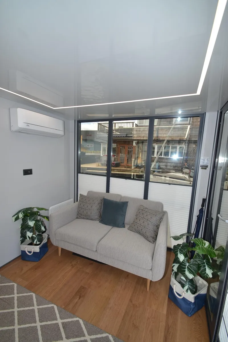 Slide: The Image of Modern 2024 La Mare Modern 11 interior with cozy sofa, plants, and large windows. - 20