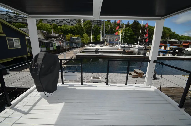Slide: The Image of Modern La Mare houseboat deck overlooking marina with sailboats, 2024 model. - 29