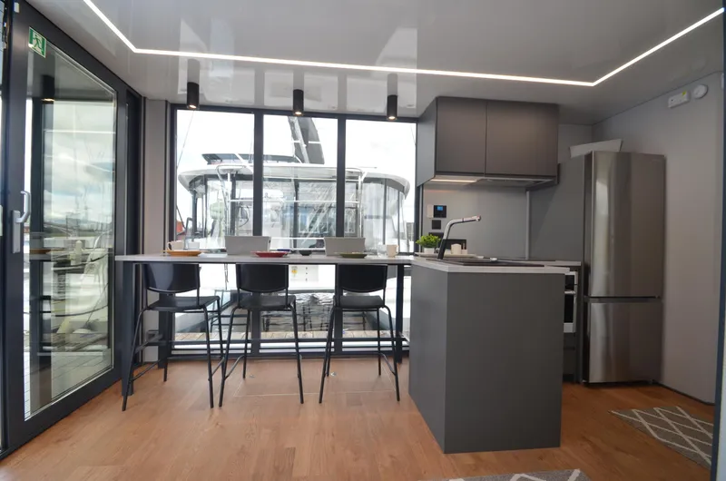 Slide: The Image of Modern kitchen interior on La Mare Modern 11 houseboat, 2024 model, featuring sleek design and large windows. - 4