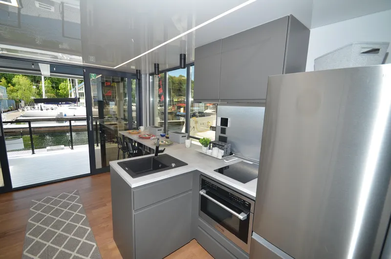 Slide: The Image of Modern kitchen in La Mare 2024 houseboat, featuring sleek gray cabinetry and stainless steel appliances. - 18