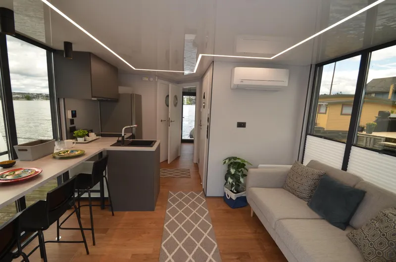 Slide: The Image of Modern 2024 La Mare houseboat interior with sleek kitchen, cozy living area, and large windows. - 9