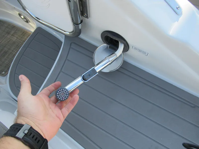 Slide: The Image of Hand holding a showerhead on a 2019 Crownline 285SS boat deck. - 14