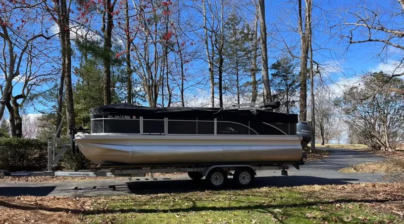 Slide: The Image of 2018 Bennington 21 SFX pontoon boat on trailer in wooded area. - 0